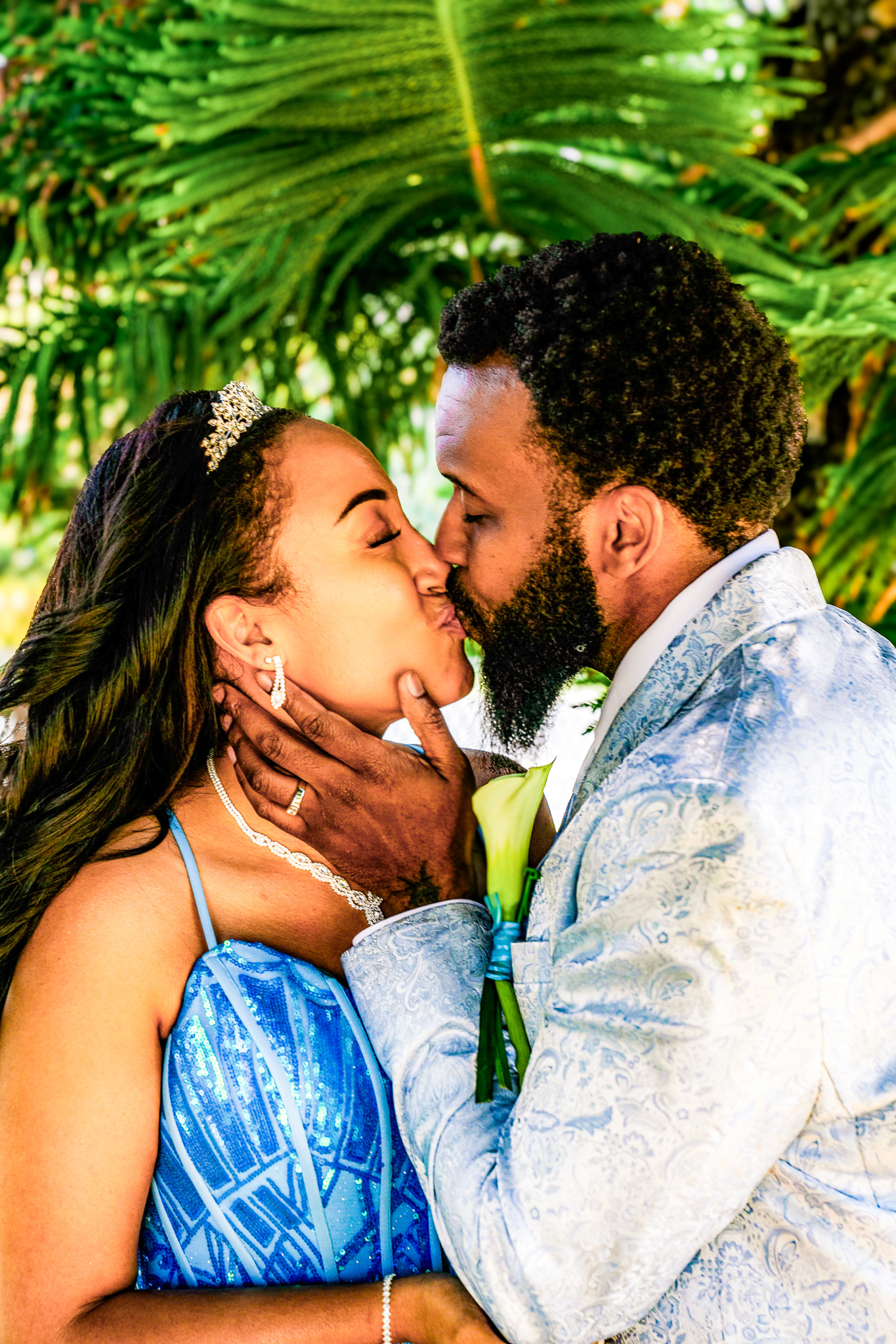Couple sharing a kiss among tropical greenery